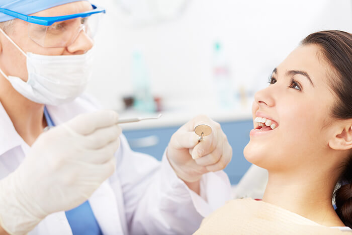 Dentista iniciando tratamento em uma paciente jovem no consultório