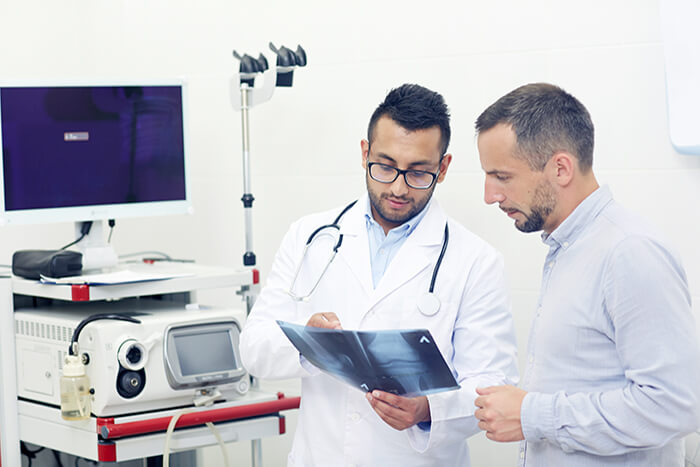 Médico e paciente vendo resultado de exame de raio-x
